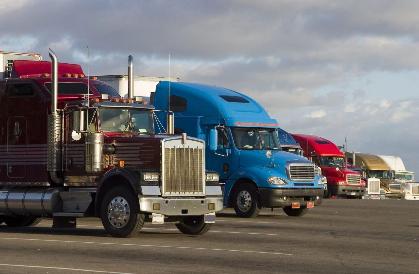A group of trucks parked on the side of a road.